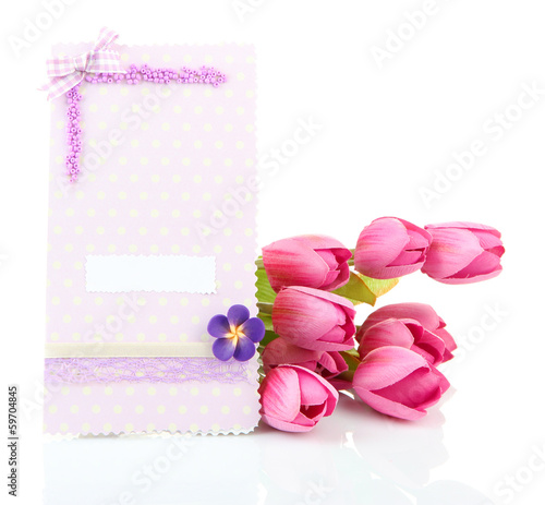 Photo: Beautiful hand made post card and flowers, isolated on white Beautiful hand made post card and flowers, isolated on white