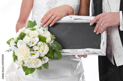 Photo: Fresh married couple holding a sign for advertising in her hands Fresh married couple holding a sign for advertising in her hands