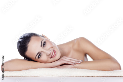 Photo: portrait of a beautiful girl lying on a towel on a white portrait of a beautiful girl lying on a towel on a white