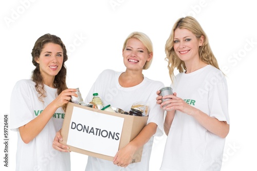 Photo: Portrait of three smiling young women with donation box Portrait of three smiling young women with donation box