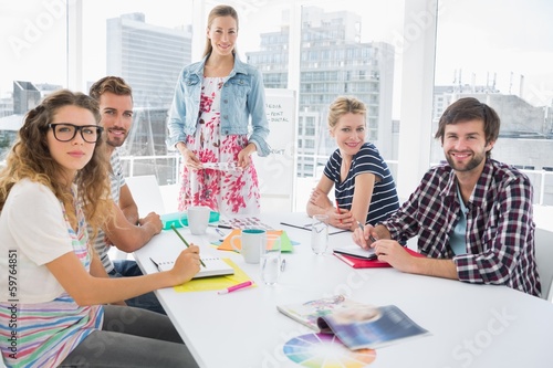Photo: Casual business people around conference table in office Casual business people around conference table in office