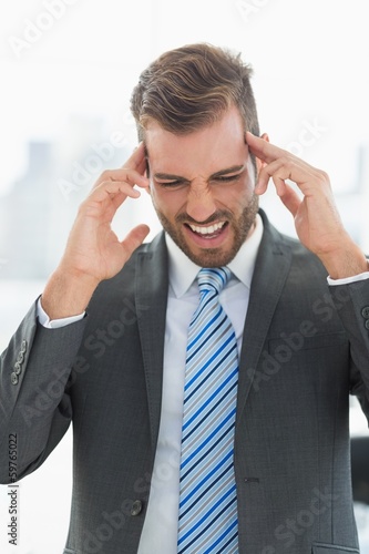 Photo: Close-up of a young businessman with headache Close-up of a young businessman with headache