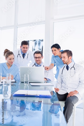 Photo: Concentrated medical team using laptop together Concentrated medical team using laptop together