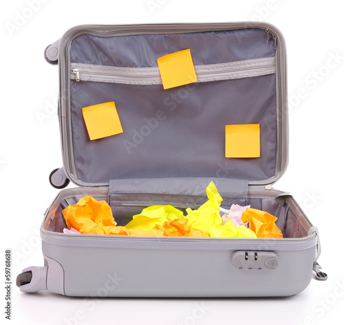 Photo: Open suitcase with paper stickers isolated on white Open suitcase with paper stickers isolated on white