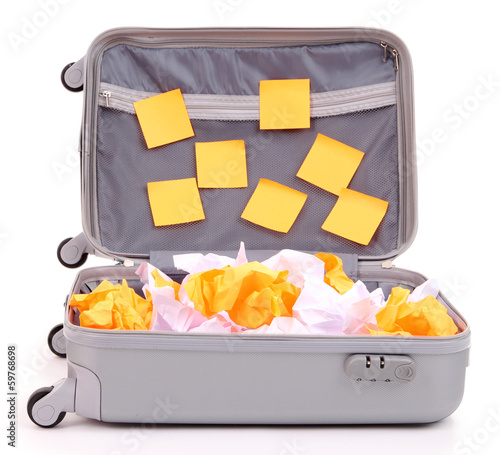 Photo: Open suitcase with paper stickers isolated on white Open suitcase with paper stickers isolated on white