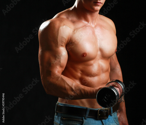 Photo: Handsome muscular man working out with dumbbells Handsome muscular man working out with dumbbells