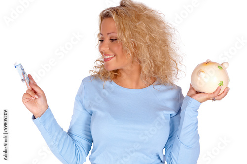 Photo: Blonde junge Frau mit Geldschein und Sparschwein in der Hand Blonde junge Frau mit Geldschein und Sparschwein in der Hand