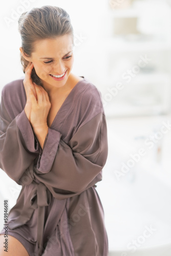 Photo: Portrait of young woman sitting in bathroom Portrait of young woman sitting in bathroom