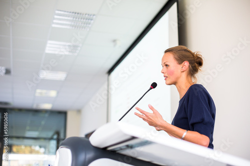 Photo: Pretty young business woman giving a presentation Pretty young business woman giving a presentation