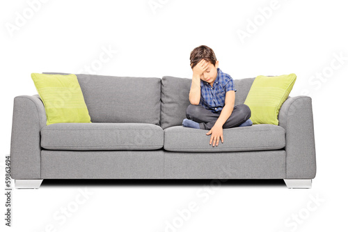 Photo: Sad boy sitting on a couch Sad boy sitting on a couch
