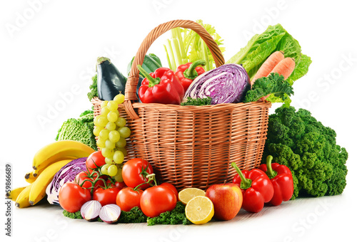 Photo: Wicker basket with assorted organic vegetables and fruits isola Wicker basket with assorted organic vegetables and fruits isola