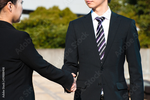 Photo: スーツ姿で握手する二人 スーツ姿で握手する二人