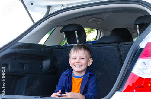 Photo: Laughing little boy sitting in the back of a car Laughing little boy sitting in the back of a car