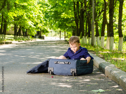 Photo: Young boy playing with an open suitcase Young boy playing with an open suitcase