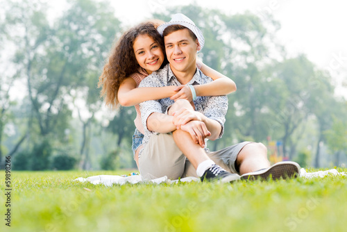 Photo: couple lying on the grass in the summer park couple lying on the grass in the summer park