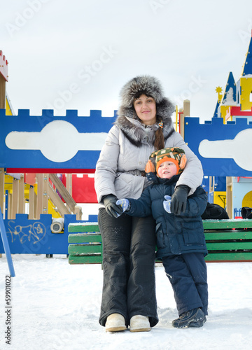 Photo: Smiling mother and son in a winter playground Smiling mother and son in a winter playground