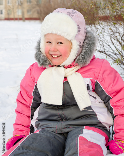 Photo: Happy little girl playing in cold winter snow Happy little girl playing in cold winter snow