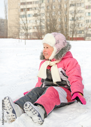 Photo: Happy little girl playing in cold winter snow Happy little girl playing in cold winter snow