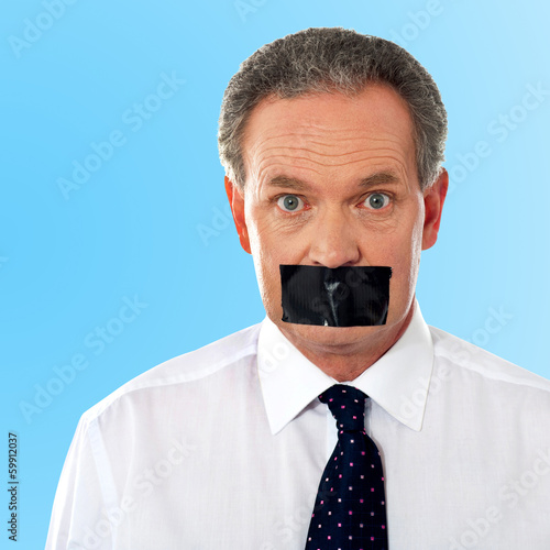 Photo: Businessman with tape on his mouth Businessman with tape on his mouth