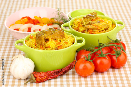 Photo: Delicious pilaf with vegetables on tablecloth background Delicious pilaf with vegetables on tablecloth background