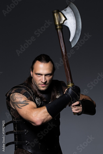 Photo: Young man with axe and historical costume Young man with axe and historical costume