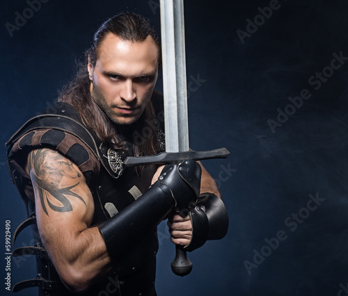 Photo: Young man with sword and historical costume Young man with sword and historical costume