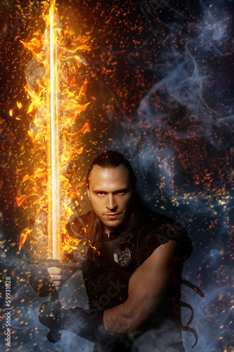 Photo: Wizardry, magic. Lone warrior with fire sword Wizardry, magic. Lone warrior with fire sword