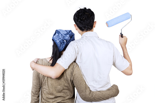 Photo: Couple ready to painting wall. isolated Couple ready to painting wall. isolated