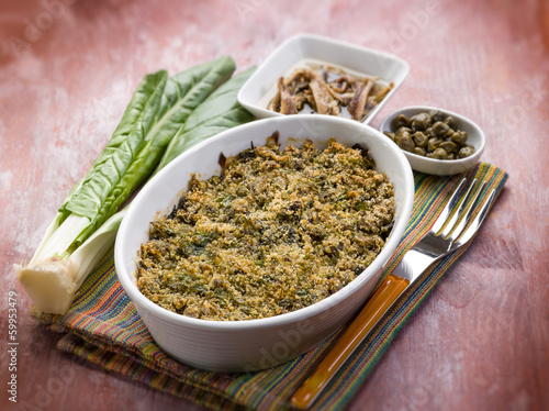 Photo: gratin of swiss chard anchovies and capers, selective focus gratin of swiss chard anchovies and capers, selective focus