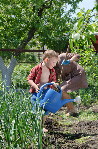 Photo: Small boy helping Mum water the vegetable garden Small boy helping Mum water the vegetable garden