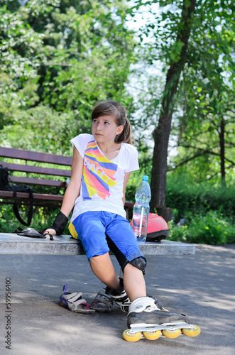 Photo: Cute teenager sitting and relaxing during skating Cute teenager sitting and relaxing during skating
