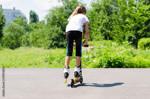 Photo: Teenage girl playing on a scooter Teenage girl playing on a scooter
