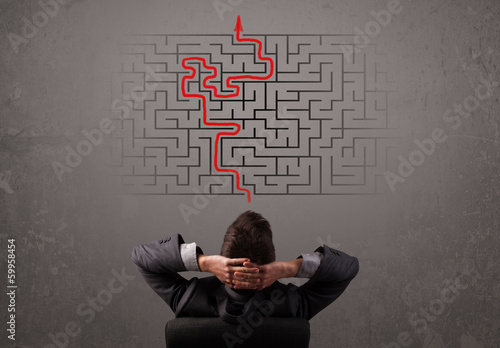 Photo: Business man looking at a maze and the way out Business man looking at a maze and the way out
