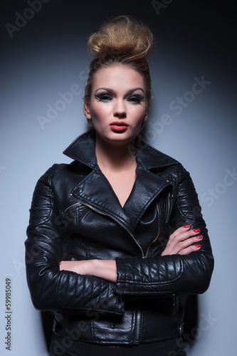 Photo: woman in leather jacket standing with arms crossed woman in leather jacket standing with arms crossed