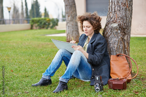 Photo: Female redhead art student drawing outdoors Female redhead art student drawing outdoors