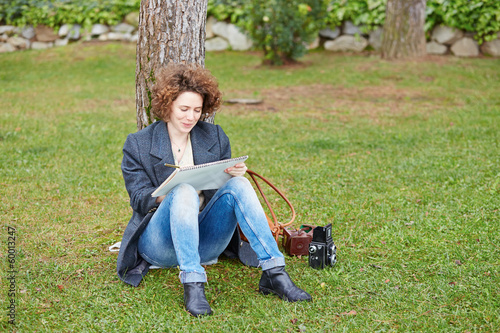 Photo: Female redhead art student drawing outdoors Female redhead art student drawing outdoors