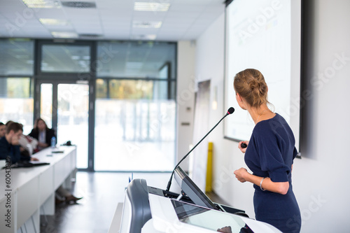 Photo: Pretty, young business woman giving a presentation Pretty, young business woman giving a presentation