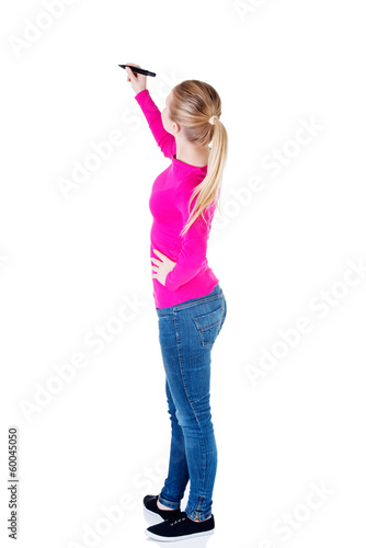 Photo: Young casual woman writing on copy space. Young casual woman writing on copy space.