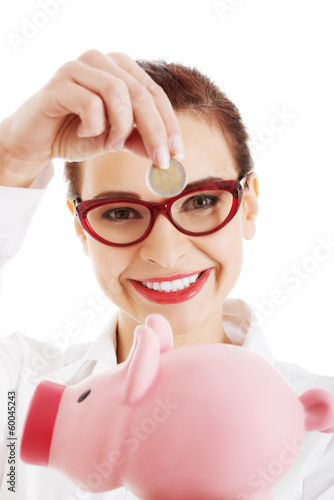 Photo: Beautiful business woman with coin and piggy- bank. Beautiful business woman with coin and piggy- bank.
