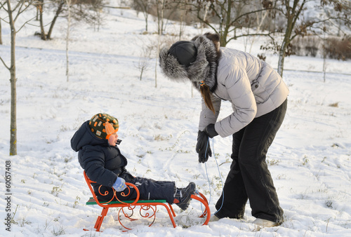 Photo: Mother and son tobogganing in the snow Mother and son tobogganing in the snow