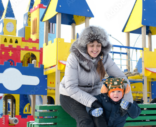 Photo: Happy mother and son in a winter playground Happy mother and son in a winter playground
