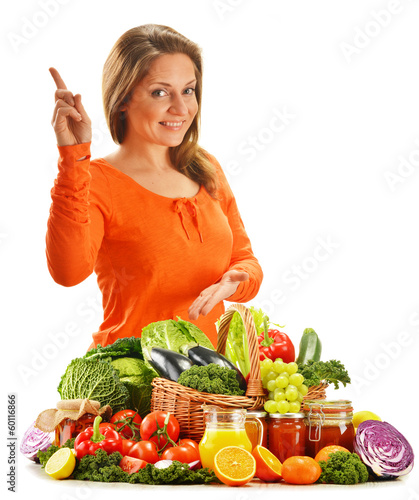 Photo: Young woman with variety of organic vegetables isolated on white Young woman with variety of organic vegetables isolated on white