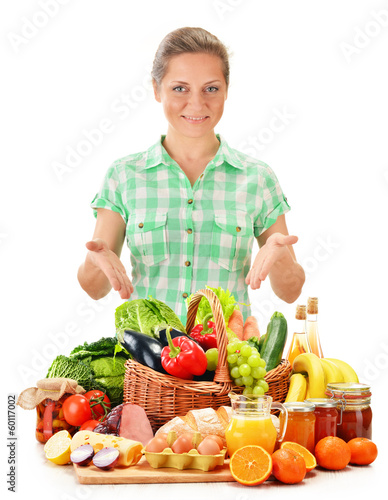 Photo: Young woman with variety of grocery products isolated on white Young woman with variety of grocery products isolated on white
