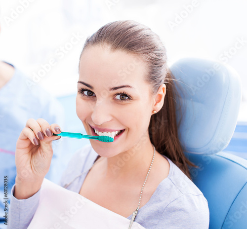 Photo: Female patient brushing her teeth Female patient brushing her teeth