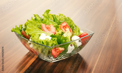 Photo: Green salat in a bowl on desk Green salat in a bowl on desk