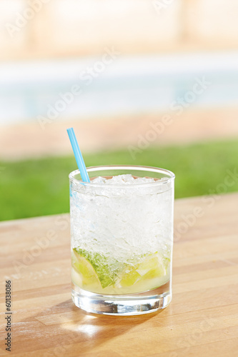 Photo: Classic caipirinha cocktail by a pool outdoors Classic caipirinha cocktail by a pool outdoors