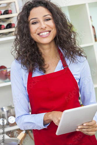 Photo: Woman Using Tablet Computer Cooking in Kitchen Woman Using Tablet Computer Cooking in Kitchen
