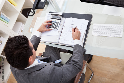 Photo: Businessman Working At Desk Businessman Working At Desk
