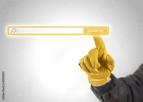Photo: hand with protective gloves pressing search button hand with protective gloves pressing search button