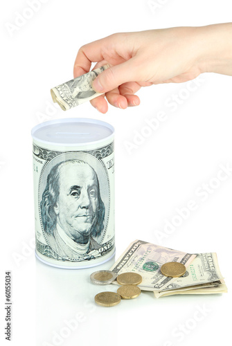 Photo: Female hand putting money in moneybox isolated on white Female hand putting money in moneybox isolated on white